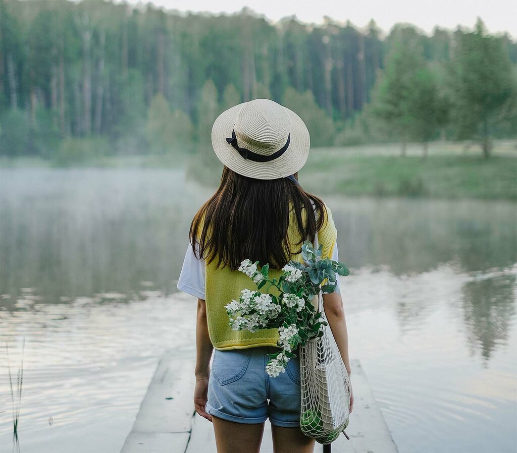 Junge Frau am See im Sommer mit Landschaft