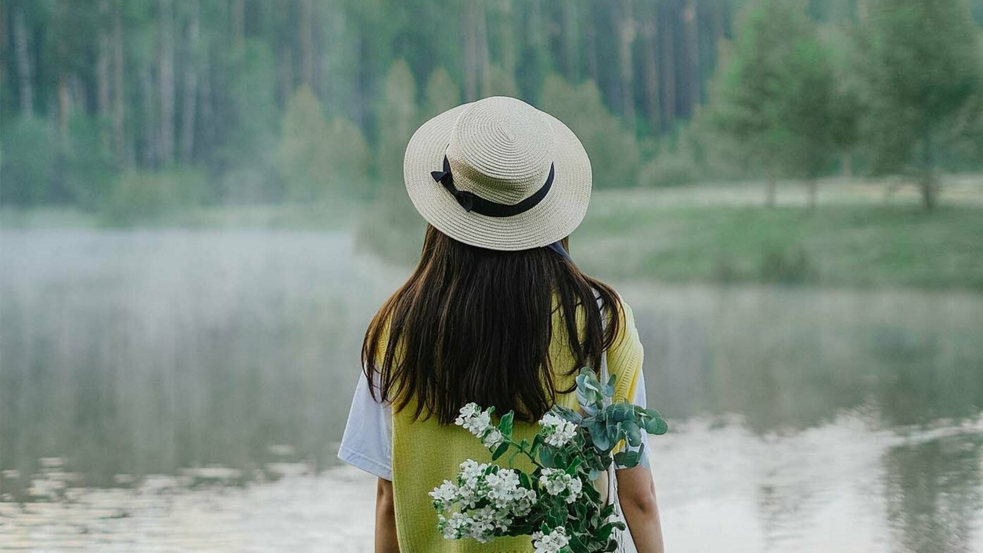 Junge Frau im Sommer am See mit Landschaft Rückansicht
