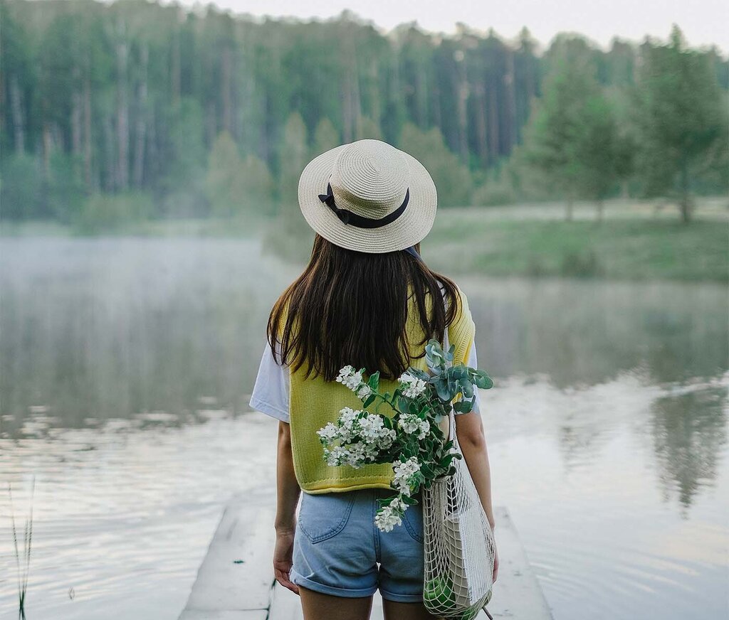 Junge Frau am See im Sommer mit Landschaft