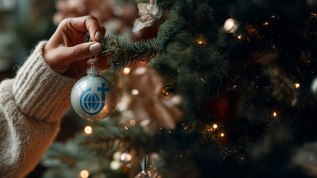 Weihnachtskugel mit Steyler Logo wird am Weihnachtsbaum aufgehängt